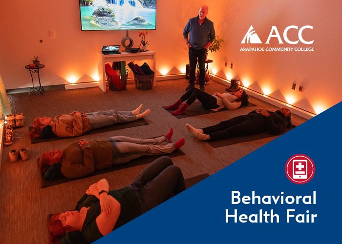 Classroom with people lying on yoga mats and candlelight. ACC logo. Behavioral Health Fair
