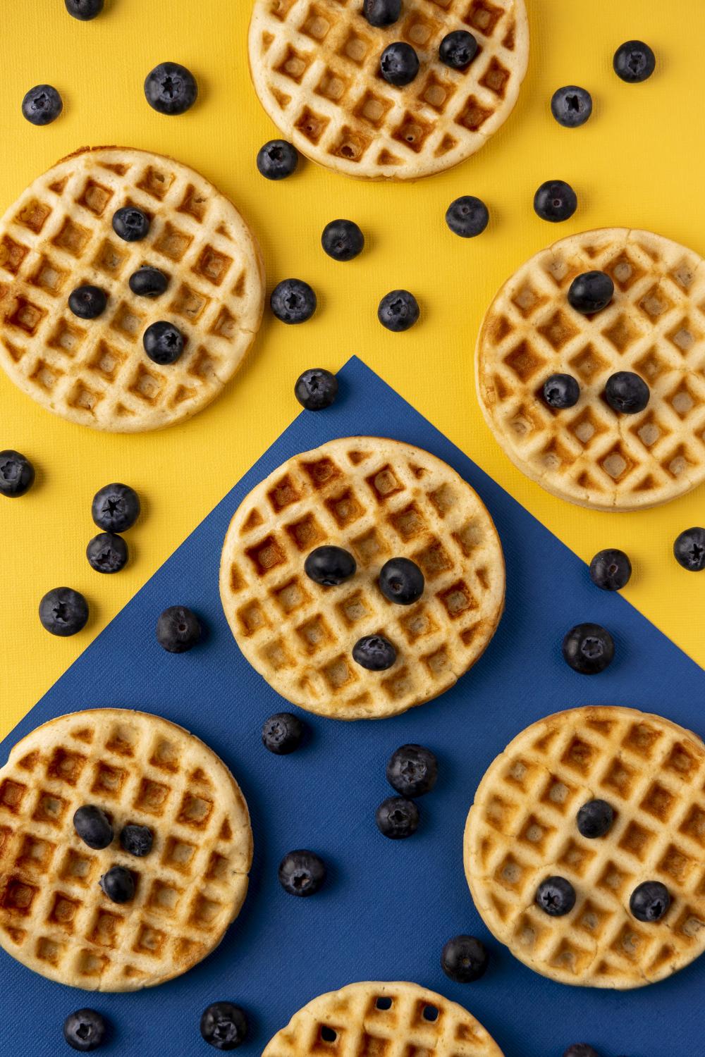 photo of waffles and blueberries on blue and yellow background - photo by Mercedes Gania