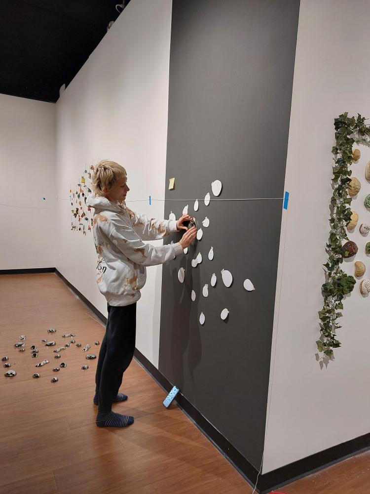 An ACC student sets up an art display in the Colorado Gallery of the Arts for the "Shared Visions" exhibition. 