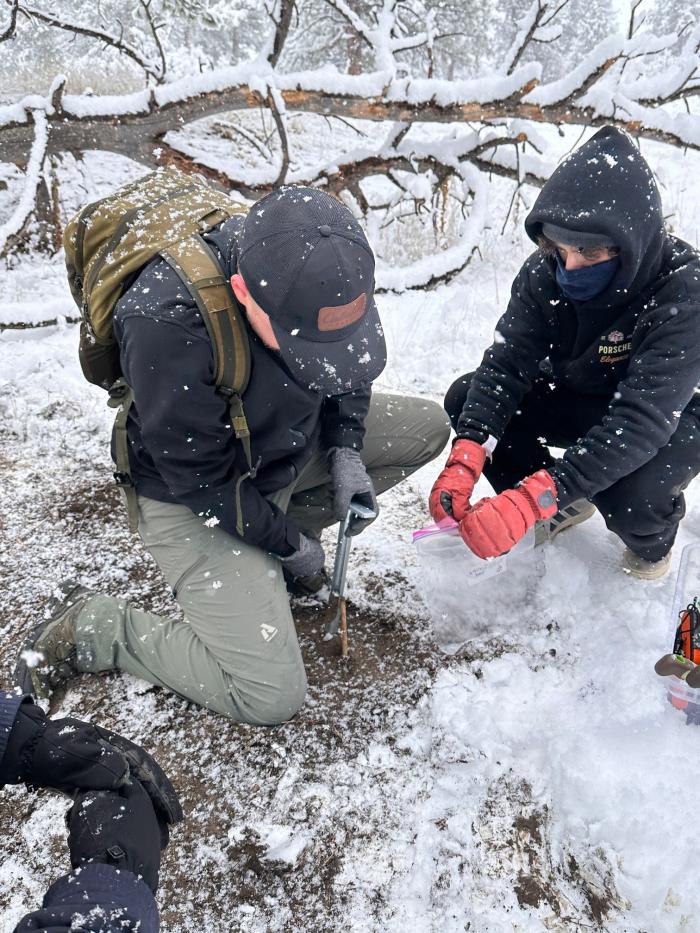 ACC Microbiology Honors Research Team members collecting soil in the snow during their field day.