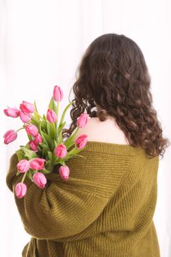 ACC student Adara Smith holding flowers and looking away from the camera
