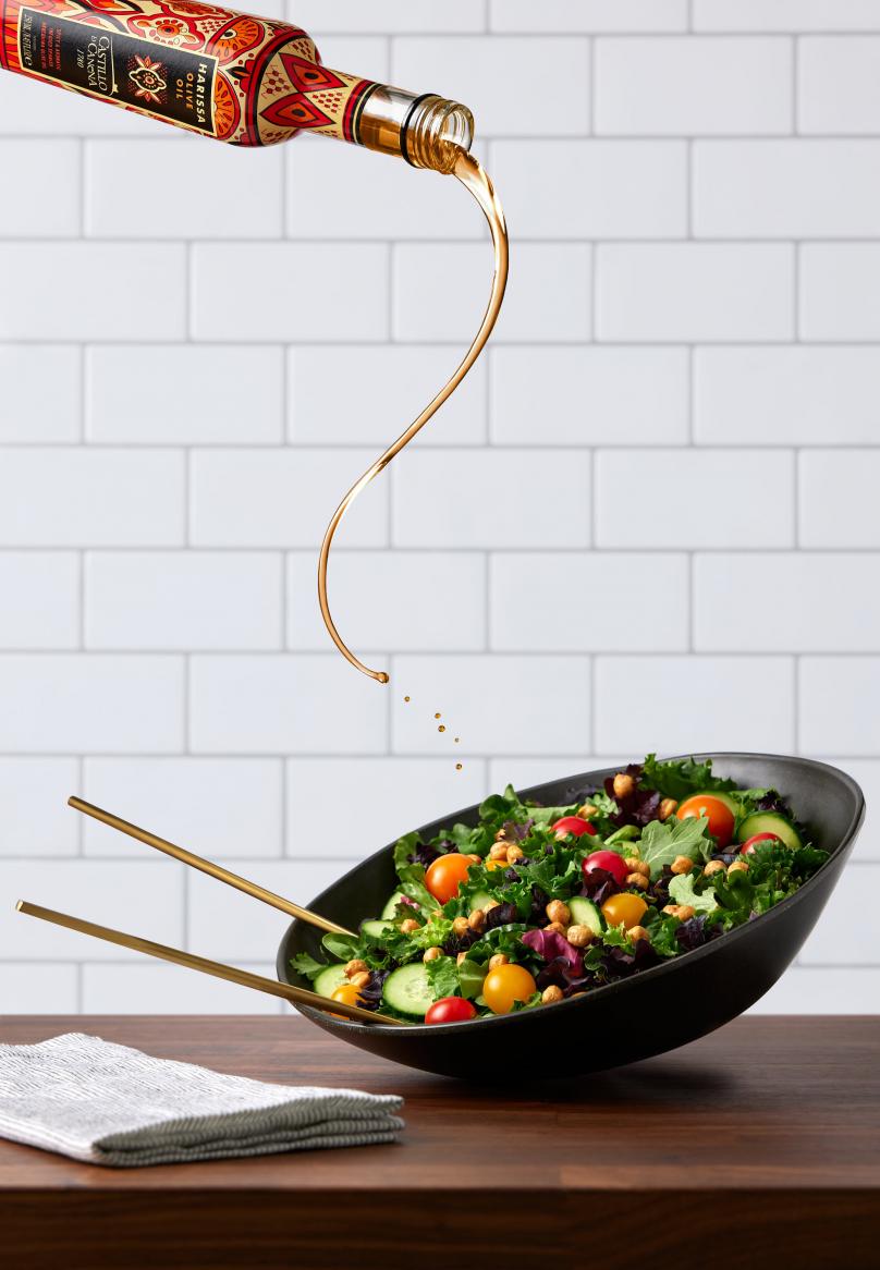 photo of oil being poured onto a salad - mid pour by Kate Blakeman