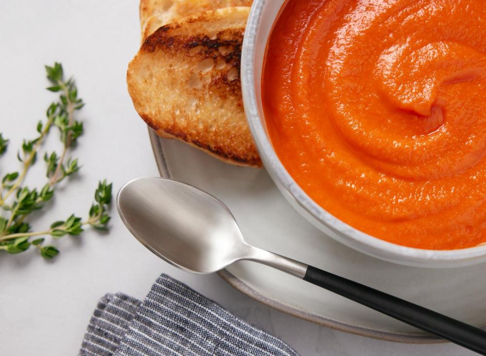 photo of tomato soup and toasted bread on a plate with a spoon by Kate Blakeman
