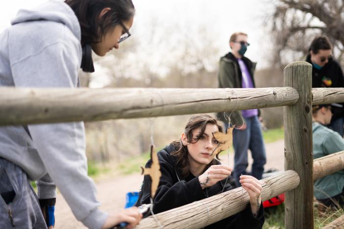 ACC students hanging birds from fence rails on the High Line Canal Trail