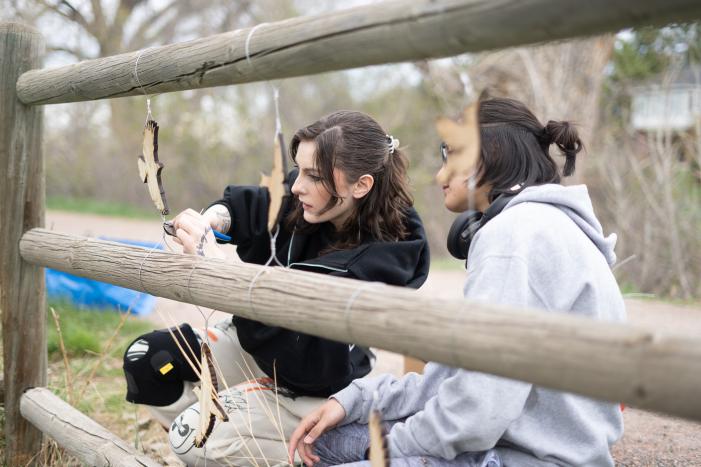 ACC students hanging birds from fence rails on the High Line Canal Trail