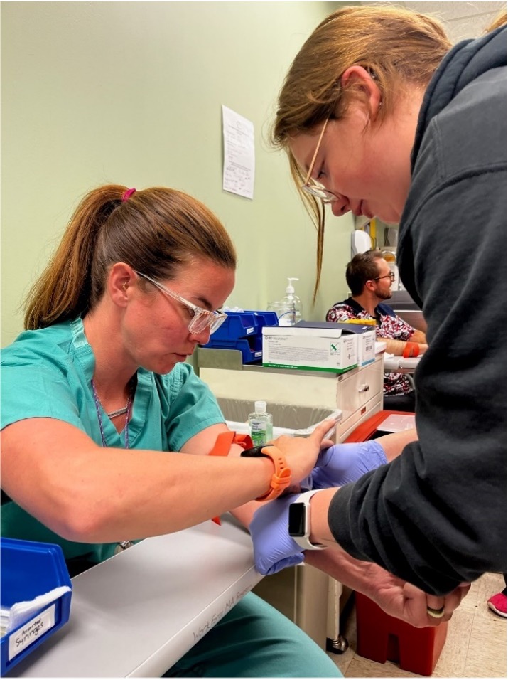 ACC medical assisting students practice skills on each other during class time.