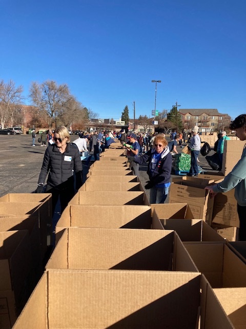 Volunteers with a line of empty boxes getting ready to fill them.
