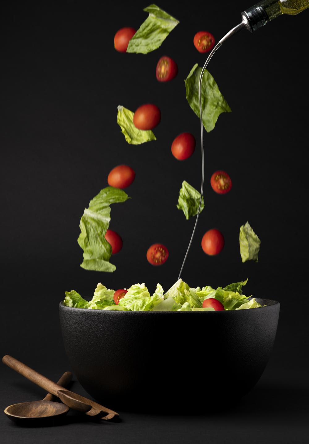 Photo of salad with oil being poured onto it - photo by Mercedes Gania