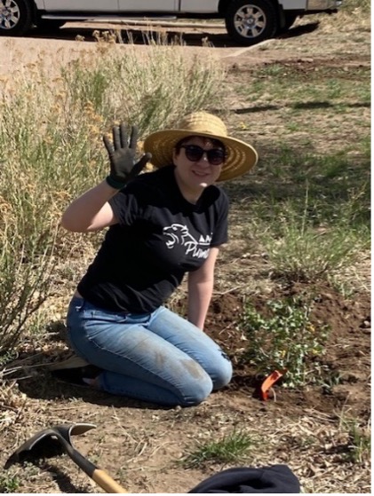 ACC volunteer weeding flowers and waving.