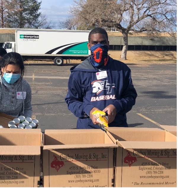 As part of a AAA 109 course Service Learning project, Student Micah Compton loads food into newly assembled boxes during the morning shift. 