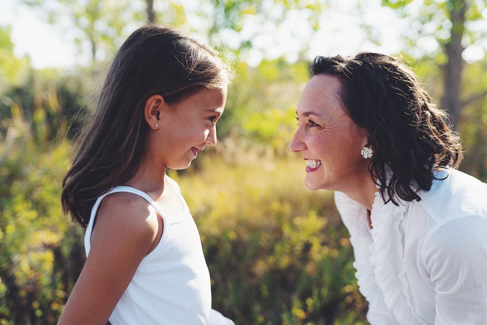 Portrait of woman and girl smiling at each other