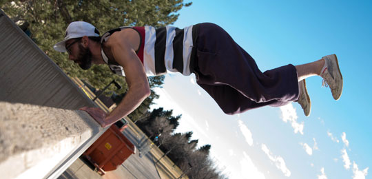 Mark D'Agosta in parkour move on ACC campus