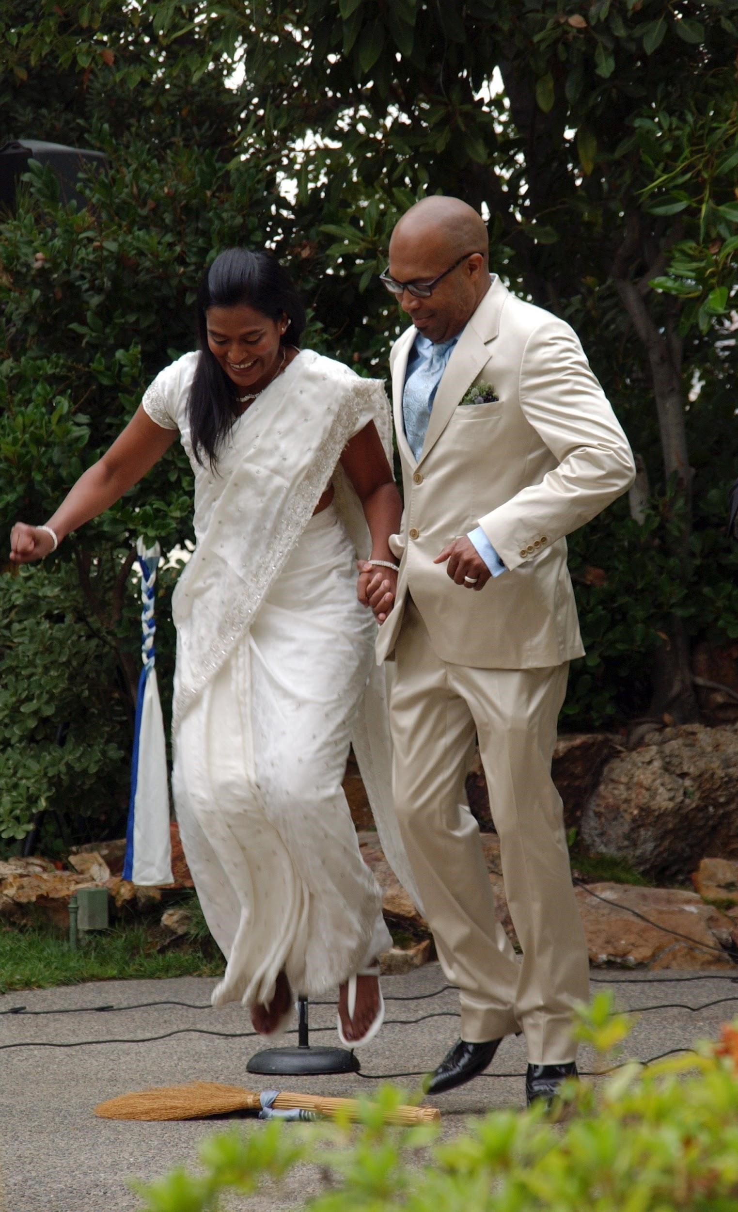 Geneses Mayes Jumping the Broom with her husband.