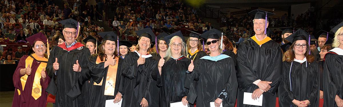 2018 ACC Graduation - faculty dressed in ragalia giving thumbs ups.