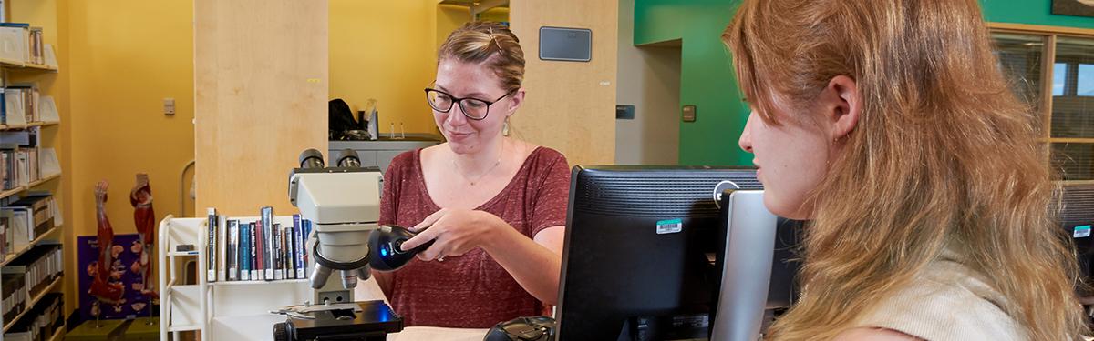 ACC students in the Library at the Littleton Campus at the circulation desk.