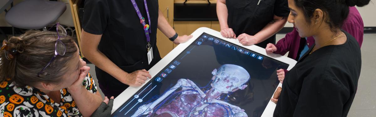 ACC students surround the Anatomage table in a cadaver lab at Sturm Collaboration Campus at Castle Rock.