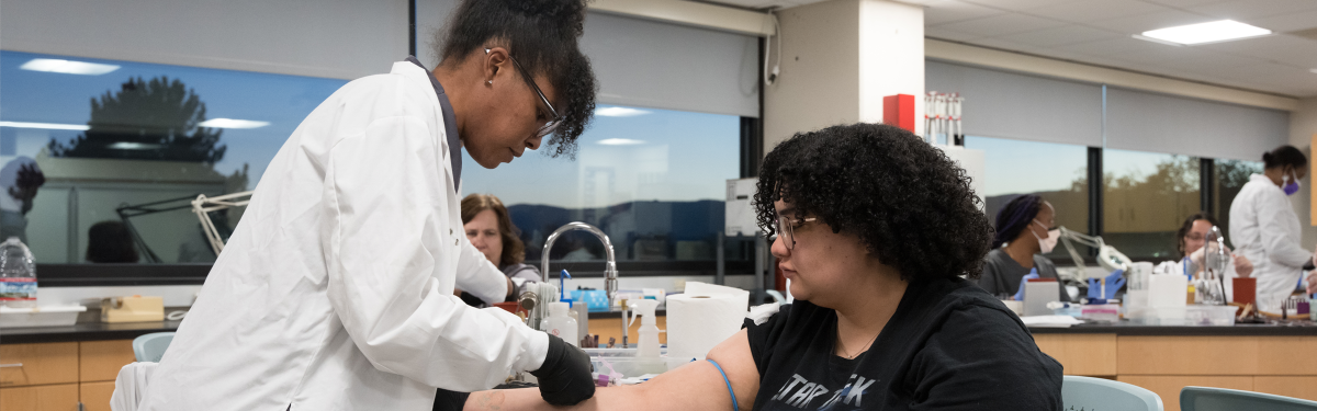 ACC Medical Laboratory Assistant students practicing phlebotomy skills during lab at the ACC Littleton Campus.