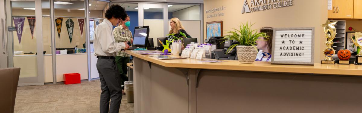 Students getting assistance from advisors and staff at the welcome desk in the Adivising & Transfer office.