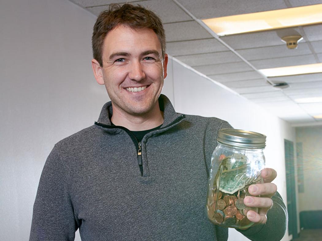 ACC student holding jar of money