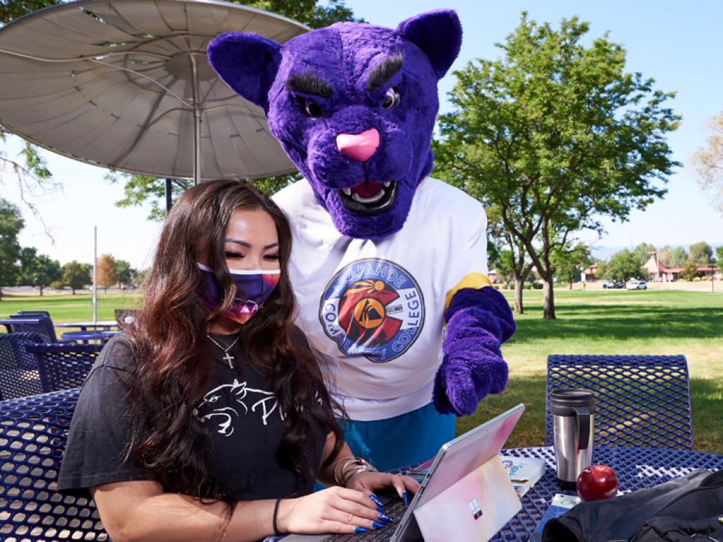 ACC student at computer with ACC Puma helping