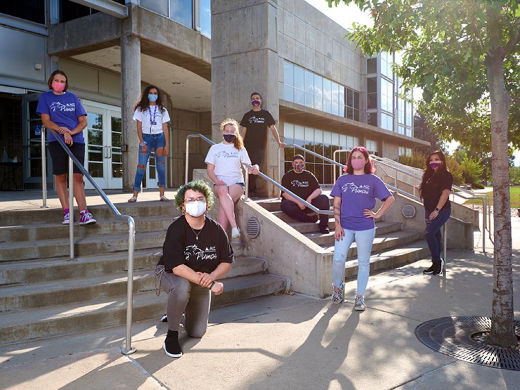 A group of ACC students stand outside the main entrance for the ACC Littleton Campus.