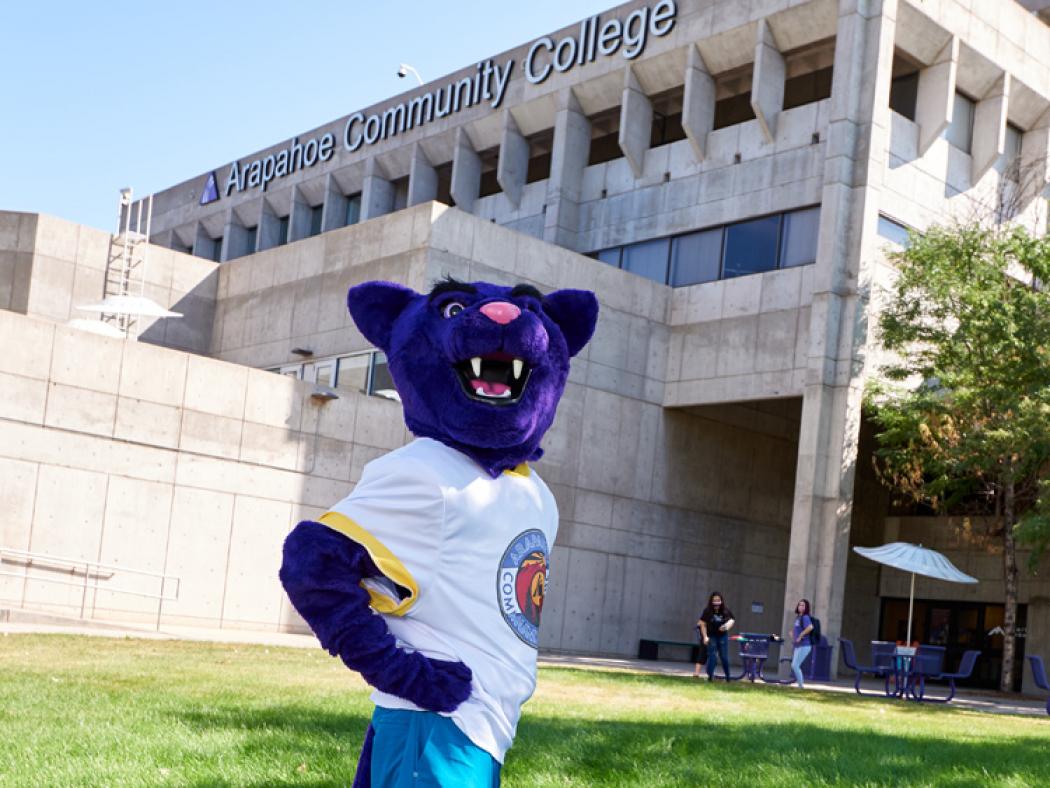 Arapahoe Community College Puma mascot poses outside of the main building on the Littleton Campus