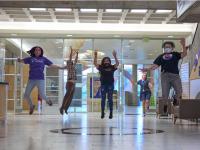 ACC students jumping in the main building on the Littleton Campus next to the Welcome Center