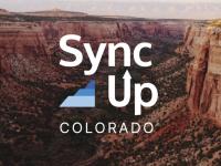 Sync Up Colorado logo over mountain photo
