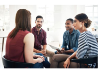 Four people sitting in a circle having a conversation.