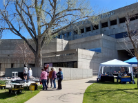 ACC Littleton Campus Main building west lawn, people exploring the outdoor craft fair.