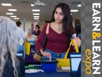 Earn & Learn Expo - ACC student at event talking to person at a table