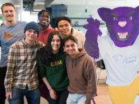 ACC students posing next to Summit the Puma mascot (cardboard cutout)