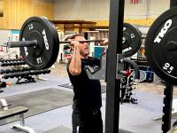 Derek Kates, ACC Fitness Center Manager, using free weights to do shoulder press in the ACC Fitness Center
