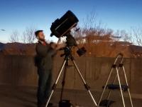 ACC student with telescopes in a field looking toward the sky at dusk.