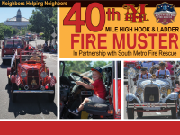 Firetrucks and response vehicles in a parade in downtown Littleton, Colorado. Child seated in driver's seat of fire truck. 
