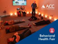 Classroom with people lying on yoga mats and candlelight. ACC logo. Behavioral Health Fair