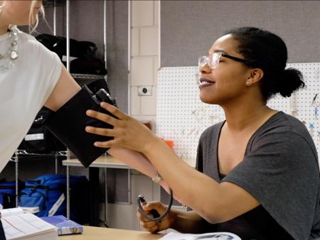 Medical Office Technology student taking blood pressure in a classroom at ACC's Littleton Campus.