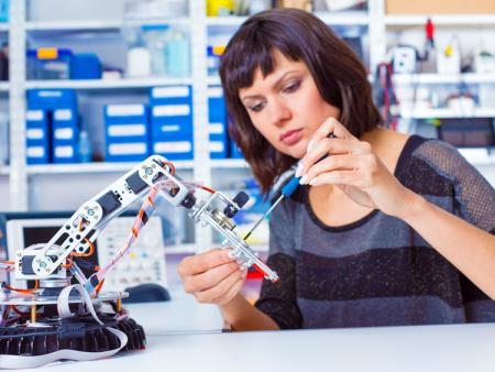 Woman working with robotic arm.