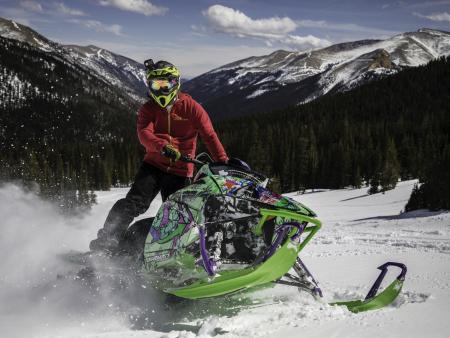 Person on snowmobile with mountains in background (photo by Lexi Salminen)