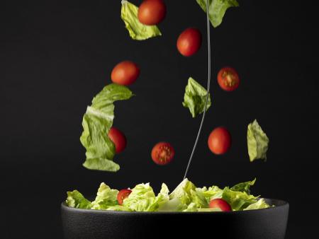 Salad mid-air falling into bowl (photo by Mercedes Peterson)