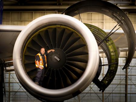 Airline worker in front of airplane engine (photo by Peggy Tio)