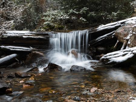 Photo of water flowing over a log into a river by Ben Howard, ACC photography student