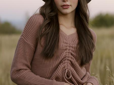 Portrait of woman in hat in a field. Photo by Kate Blakeman, ACC photography student