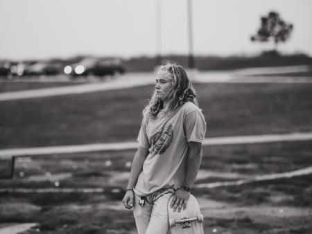 Photo of woman holding a skateboard at park. Photo by Mary Schulte, ACC photography student