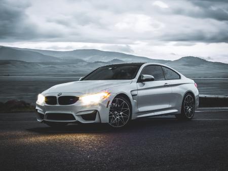 Gray BMW with headlights on in front of mountains. Photo by Matthew Greenfield, ACC photography student
