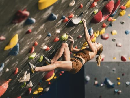 Woman climbing rock wall. Photo by Nick Palmer, ACC photography student