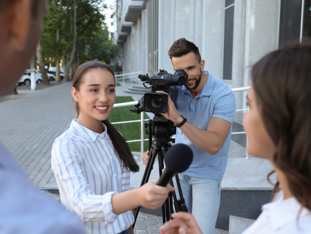Students with camera and microphone conducting an interview for their Journalism class.
