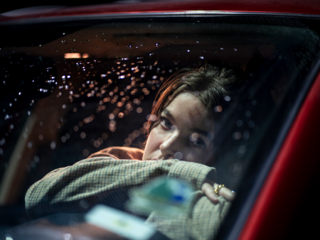Photo of woman in a car window in the dark with raindrops - photo by Thomas Larson