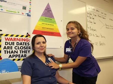ACC Nurse Aide students practicing vital checks on one another.