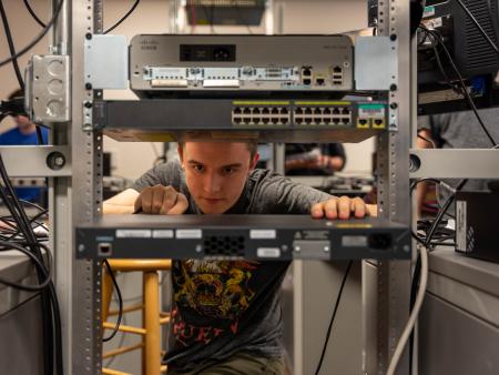 Arapahoe Community College Computer Information Systems (CIS) student working on a rack in the classroom (Littleton Campus).